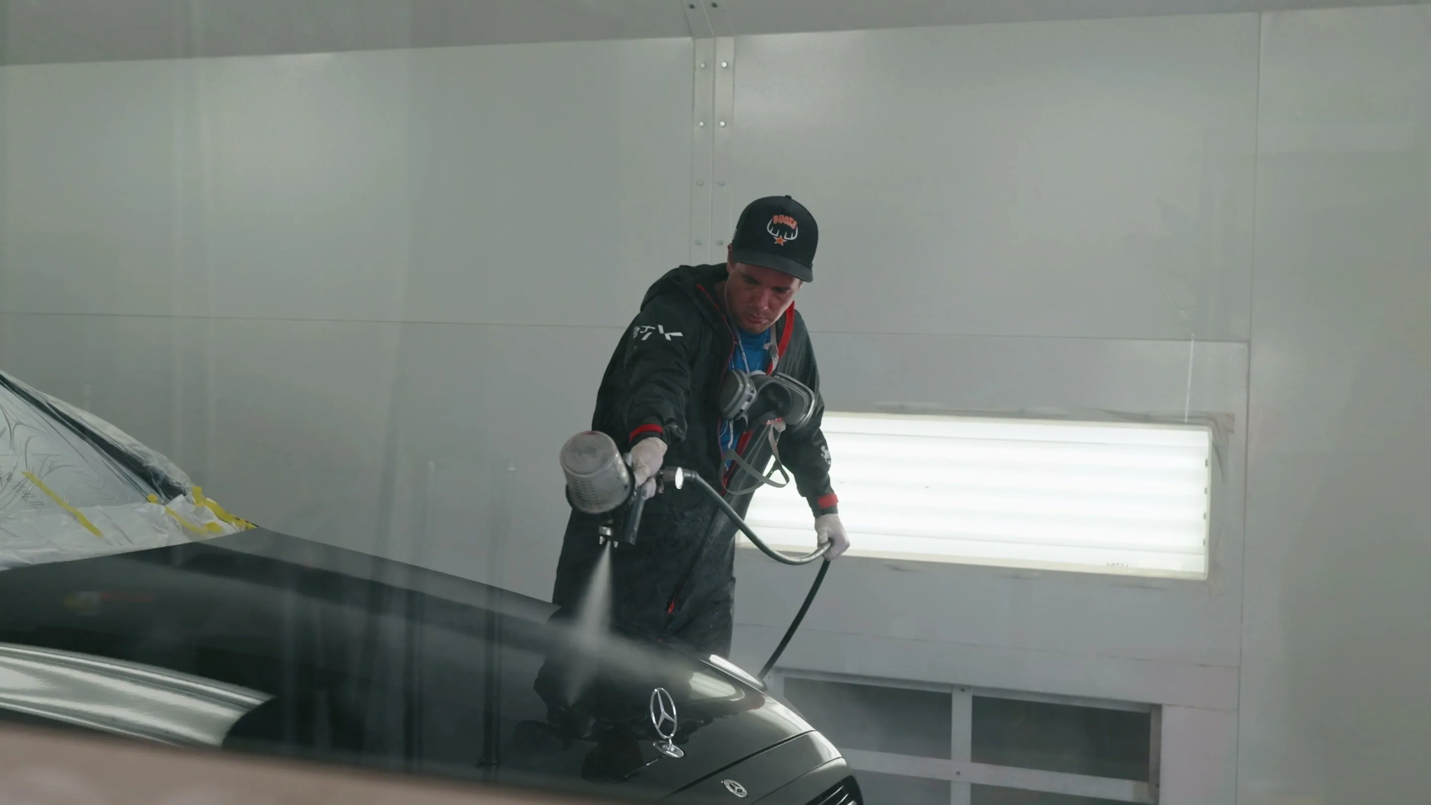 Royal Armor technician spraying Peel Clear on a hood in the booth